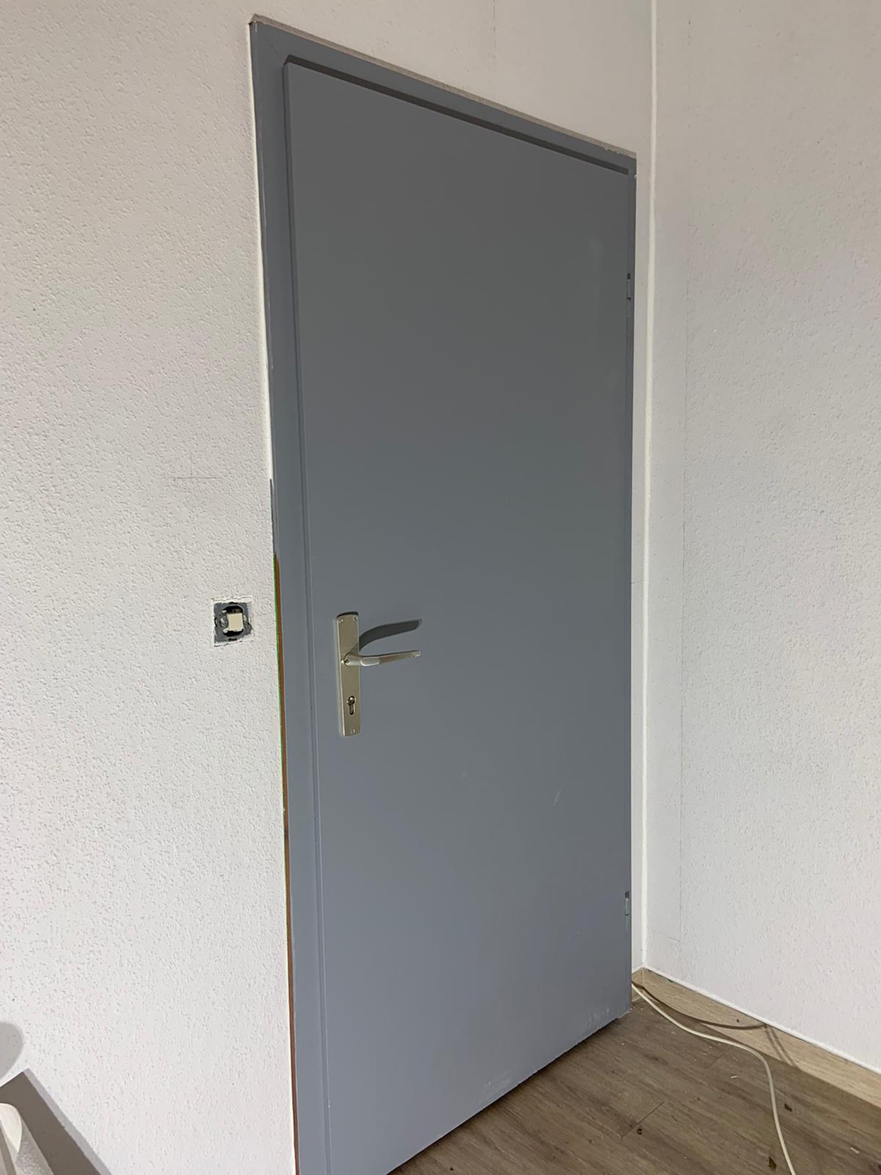 Das Renovierungsobjekt: eine abgenutzte Zimmertür mit lösemittelhaltiger Altlackierung.