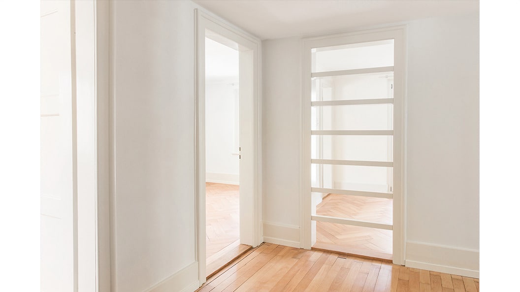 Altbau: Eine Tür wird als Regal genutzt und lässt Tageslicht in den innenliegenden Korridor.